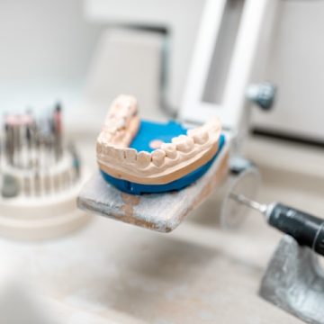 Artificial jaw for implants modeling with set of dental burs at the working place of dental technician in the laboratory